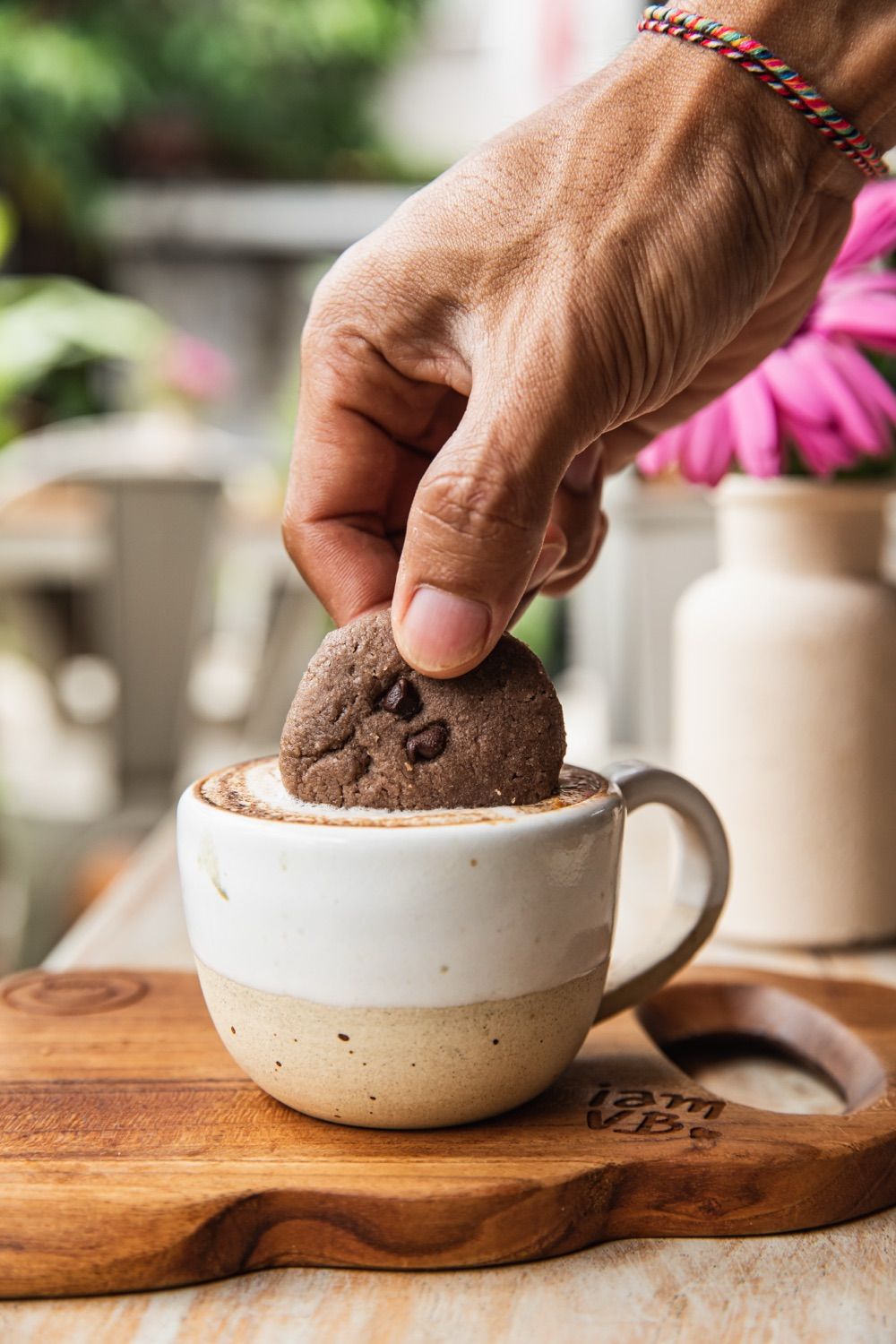 A cookie dipped into a cappuccino